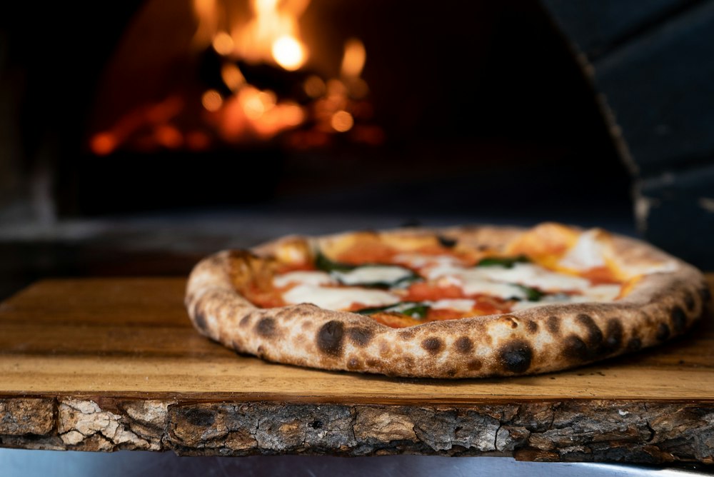 Pizza appena sfornata sulla pala davanti al forno